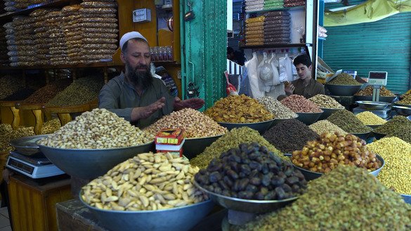 A shopkeeper prepares dried fruit and nuts as he waits for customers May 26 in Kabul. [Wakil Kohsar/AFP]