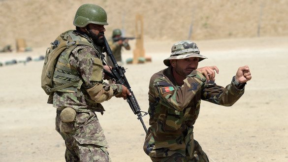 In this photograph taken on August 10, 2017, an Afghan commando instructor explains how to fire during live firing exercises at Camp Morehead on the outskirts of Kabul. [Shah Marai/AFP]