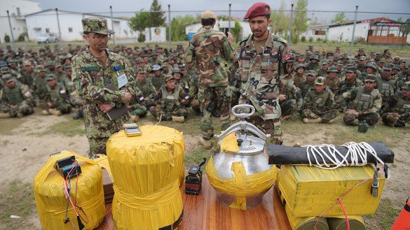 In this photograph taken on May 3, 2017, Afghan National Army soldiers look at an Afghan-made improvised explosive device at the Kabul Military training centre in the outskirts of Kabul. [Shah Marai/AFP]