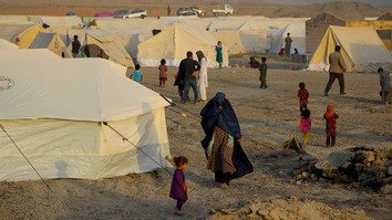 افغان های بیجا شده در اثر نبردهای روان علیه شبه نظامیان طالبان در روز 18 میزان گذشته در داخل یک کمپ موقت در ولایت تخار راه می روند. بنا بر دفتر هماهنگی امور بشردوستانه سازمان ملل متحد (اُ سی اچ اِی) حدود 250 هزار افغان در نتیجه جنگ خانه ها شان را ترک کردند.