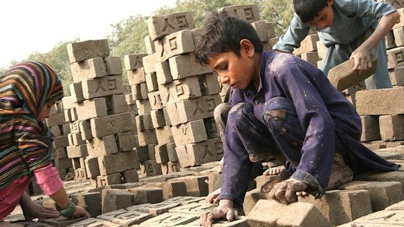 Zaikrullah and his siblings turn bricks to dry in the sun. Thousands of children are stuck working in brick factories, helping their families work off debt, say Nangarhar Province authorities. [Khalid Zerai]