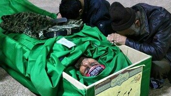 دو نفر در یک مراسم تدفین در جعفرآباد ایران کشته شدن یک عضو فرقه فاطمیون که در سوریه کشته بود را به سوگ نشسته اند. به گفته تحلیلگران، شیعیان افغان کشته شده در حال جنگ در سوریه اغلب در ایران دفن می شوند.