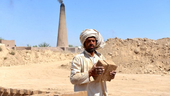 A labourer collects bricks at a brick factory in Kandahar Province July 17. [Javed Tanveer/AFP]