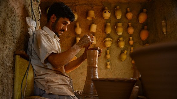 A potter works on a clay pot on the outskirts of Herat July 12. [Hoshang Hashimi/AFP]