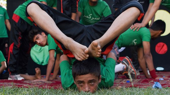 Children perform during the Mobile Mini Circus for Children at the Bagh-e-Babur Garden in Kabul on August 1, 2018. [Wakil Kohsar/AFP]