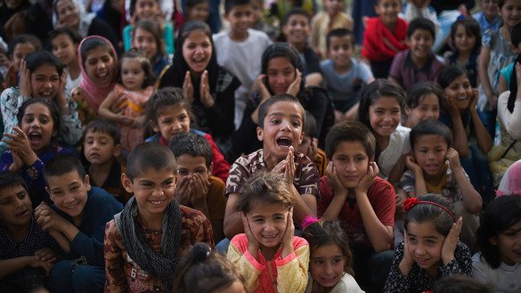 Children cheer and react as they watch a performance of the Mobile Mini Circus for Children at the Bagh-e-Babur Garden in Kabul on August 1, 2018. [Wakil Kohsar/AFP]