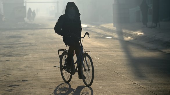 A bicyclist rides with his face covered in heavy smog in Kabul January 17. [WAKIL KOHSAR/AFP]