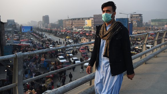 A man wearing a face mask walks along an overpass amid heavy smog in Kabul January 16. [WAKIL KOHSAR/AFP]