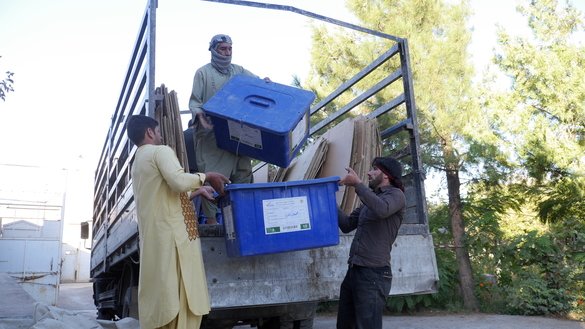 در این تصویر، کارمندان کمیسیون مستقل انتخابات هرات به تاریخ ۲۵ سنبله دیده می شوند که، صندوق های رأی را در موترهای لاری در شهر هرات بارگذاری می کنند. [فرید ظاهر/ای اف پی]