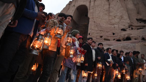 Bearing lamps, local residents and activists during a 20th anniversary remembrance ceremony on March 9 stand at the base of the cliff where the Salsal Buddha once stood. The Taliban destroyed the Buddhas of Bamiyan in March 2001. [Wakil Kohsar/AFP]