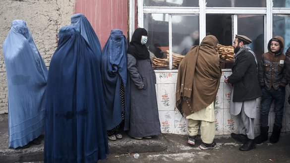People wait to receive free bread distributed as part of the Save Afghans From Hunger campaign in front of a bakery in Kabul on January 18. [Wakil Kohsar/AFP]