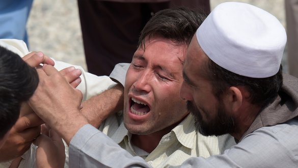 A mourner (centre) weeps for those who were killed in a Kabul suicide bombing on July 23. The "Islamic State of Iraq and the Levant" (ISIL) claimed responsibility for the twin explosions targeting a Shia crowd. At least 80 Afghans were killed. [Shah Marai/AFP]