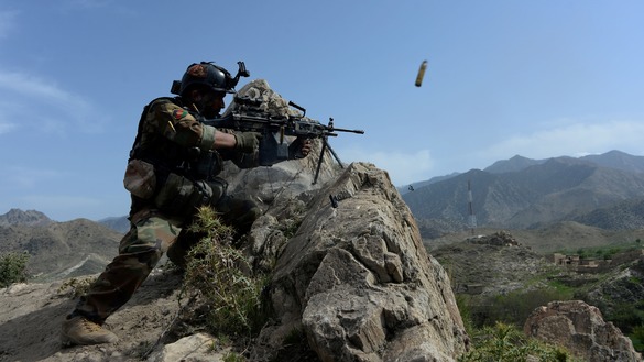 An Afghan soldier April 11 in Achin District, Nangarhar Province, opens fire during an operation against "Islamic State of Iraq and the Levant" (ISIL) militants. [Noorullah Shirzada/AFP]