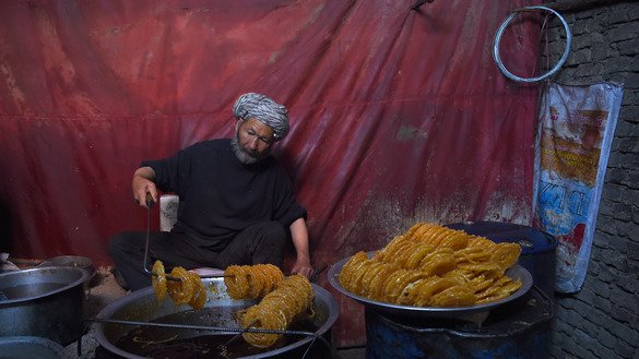 یک مردم افغان در تاریخ (5 جوزا) در کابل مصروف تهیه حلویات سنتی است. [وکیل کوهسار/ خبرگزاری فرانسه]
