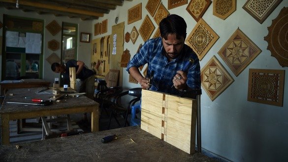 شاگردان افغان روی یک حکاکی مشبک کاری (جالی) روی چوب کار می کنند. [وکیل کوهسار/ خبرگزاری فرانسه]