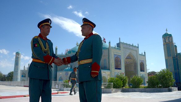 Members of an honour guard greet each other June 15 after offering Eid ul Fitr prayers in Mazar-e-Sharif. [Farshad/Usyan/AFP]