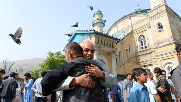 Muslims hug each other after offering prayers at the start of Eid ul Fitr at the Shah-e Do Shamshira mosque in downtown Kabul June 15. [Noorullah Shirzada/AFP]