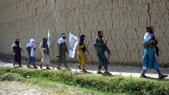 جنگجویان طالبان بتاریخ ۲۶ جوزا در حومه جلال آباد راه می روند. آنها بمناسبت آتش بس در دومین روز عید فطر به سرک آمده اند. [نورالله شیرزاده/ خبرگزاری فرانسه]