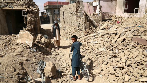 Residents August 16 walk near destroyed houses after a Taliban attack in Ghazni. [ZAKERIA HASHIMI/AFP]