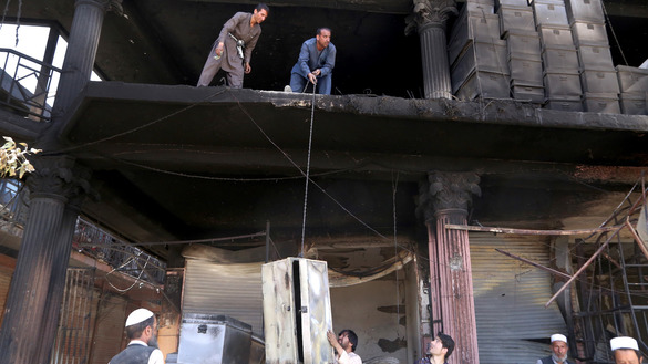 بتاریخ ۲۳ اسد، دوکان داران بعد از آن که طالبان یک مارکیت را در شهر غزنی به آتش کشیدند، اجناس تخریب شده را از یک دوکان خارج می کنند. [زکریا هاشمی/ خبرگزاری فرانسه]