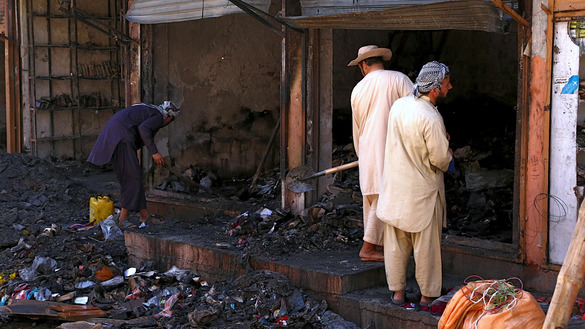 Shopkeepers August 14 clear debris from a shop after the Taliban burned a market area in Ghazni city. [ZAKERIA HASHIMI/AFP]