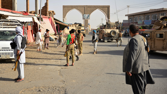 Afghan security forces and Afghan militia stand along a road August 12 during clashes with the Taliban in Ghazni Province. [Mohammad Anwar Danishyar/AFP]