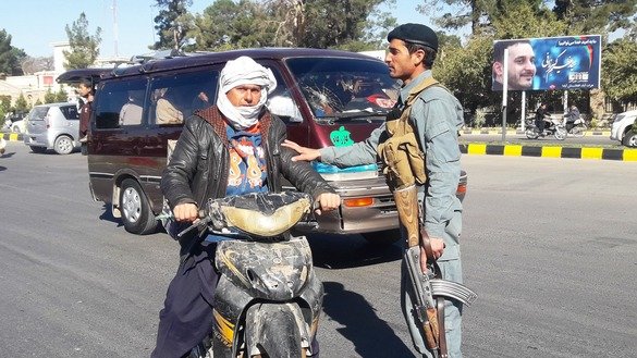 یو افغان پولیس افسر له پارلماني انتخاباتو څخه دوه ورځې مخکې د تلې په ۲۶مه په هرات ښار کې له یوه موټرسایکل سپاره سړي څخه پوښتنې کوي. [نصیر صالحي]