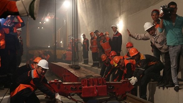 کارگران راه آهن ازبیکستان قبل از افتتاح تونل کامچیک در دره فرغانه در سال ۲۰۱۶ میلادی عملیات ریل گذاری را تکمیل می کنند. [خط آهن ازبیکستان]
