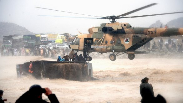An Afghan military helicopter rescues flood survivors from atop an overturned truck in  Arghandab District, Kandahar Province, March 2. [Javed Tanveer/AFP]