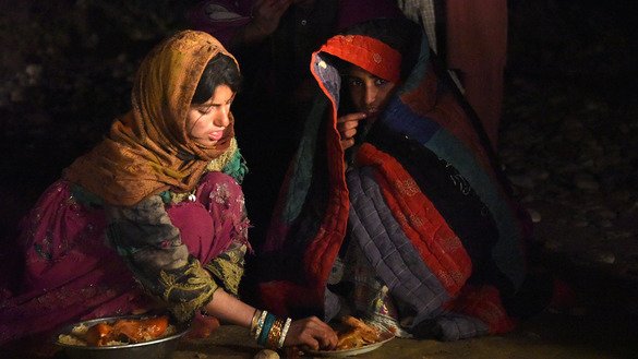 Afghans displaced by flooding eat in Arghandab District, Kandahar Province, March 3. Flash flooding killed at least 20 residents of Kandahar Province, said the UN March 2, as heavy rains swept away houses and vehicles and potentially damaged thousands of houses. [Javed Tanveer/AFP]