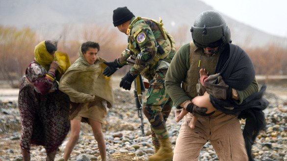 An Afghan Air Force crew member March 2 carries a baby during a flood evacuation in Arghandab District, Kandahar Province. [Javed Tanveer/AFP]