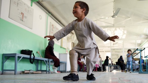 Ahmad Sayed Rahman, a five-year-old Afghan boy who lost his right leg when he was hit by a bullet in the crossfire of a battle, dances with his prosthetic leg at the International Committee of the Red Cross (ICRC) hospital for war victims and the disabled in Kabul on May 7. [Wakil Kohsar/AFP]