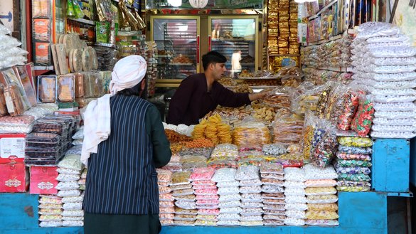 A shopkeeper interacts with a customer in Herat city on May 25. As Ramadan comes to an end, residents buy dried fruits and sweets to prepare for the celebration of Eid ul Fitr that follows. [Omar]