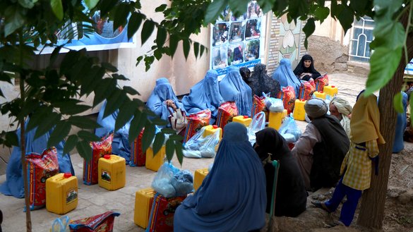 زنان و کودکان به تاریخ ۲جوزا در شهر هرات مواد خوراکه دریافت می کنند. تجاران افغان و باشنده گان پول دار در جریان ماه رمضان به فقرا کمک میکنند. [عمر]