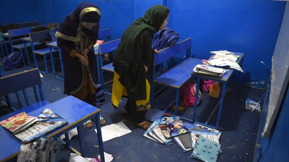 دختران مکاتب افغان به تاریخ ۱۱ سرطان در کابل بکسه ها و کتاب های شان را در نزدیک محل انفجار موتربم طالبان که به تاریخ ۱۰ سرطان رخ داد جمع آوری می کنند. [وکیل کوهسار/ای اف پی]