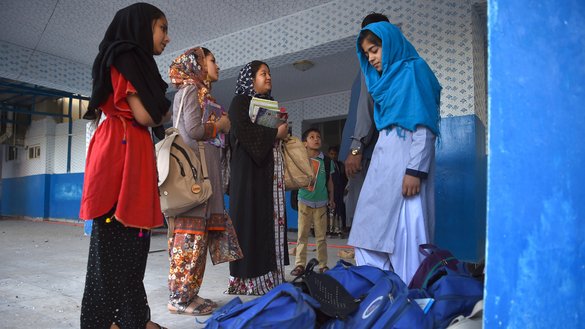 دختران مکاتب افغان به تاریخ ۱۱ سرطان درکابل بکسه ها و کتاب های شان را در نزدیک محل انفجار موتربم طالبان که به تاریخ ۱۰ سرطان رخ داد جمع آوری می کنند. [وکیل کوهسار/ای اف پی]
