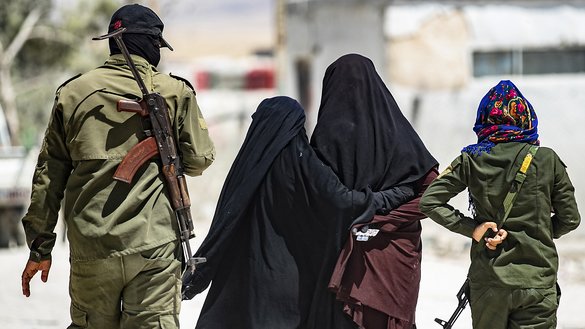 In this file photo taken on July 23, an internal security patrol escorts women, reportedly wives of ISIS fighters, in the Al-Hol camp in northeastern Syria. [Delil Souleiman/AFP]