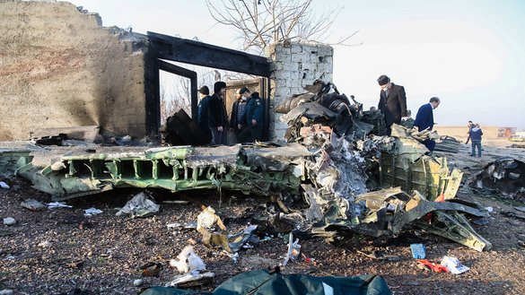 Passersby stand near the wreckage after a Ukrainian plane carrying 176 passengers crashed near Imam Khomeini airport in Tehran on January 8. Three days later, on January 11, the Islamic Revolutionary Guard Corps admitted to accidentally shooting down the plane. [Rouhollah VAHDATI / ISNA / AFP]