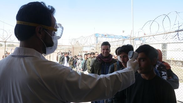 A health worker screens an Afghan returnee from Iran at the Islam Qala border crossing in Herat Province for the coronavirus on March 11. [Omar]