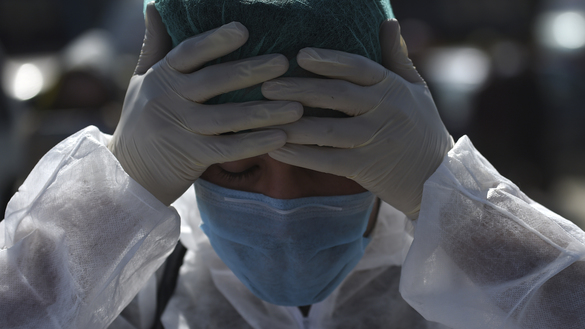 A volunteer wearing a hazmat suit and a facemask prepares before the start of a preventive campaign against the spread of the COVID-19 coronavirus in Kabul on March 18, 2020. [Wakil Kohsar/AFP]