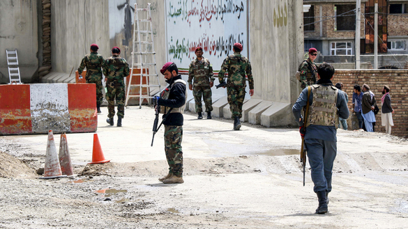 Security personnel gather on April 29 near a military outpost on the outskirts of Kabul where a suicide bomber killed at least three people and wounded 15 others. [STR/AFP]