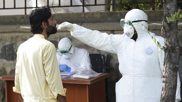 In this photograph taken May 9 a medic wearing personal protective equipment takes a swab sample from a suspected COVID-19 coronavirus patient at the Afghan-Japan Communicable Disease Hospital in Kabul. [Wakil Kohsar/ AFP]