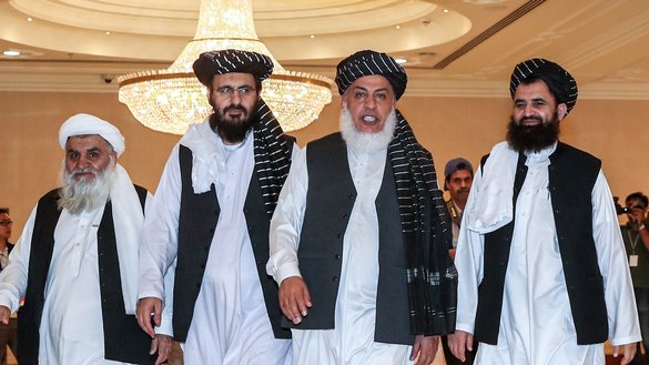 در تصویر دیده می شود که، محمد نبی عمری، یک عضو گروه طالبان که قبلاً در گوانتانامو زندانی بود (سمت چپ در وسط)، شیرمحمد عباس استانکزی مذاکره کننده طالبان (سمت راست در وسط) و مولوی عبدالحق وثیق معاون پیشین استخبارات طالبان (سمت راست)، با یک عضو دیگر گروه طالبان به تاریخ ۱۷ سرطان ۱۳۹۸ در جریان روز دوم مذاکرات بین الافغانی در دوحه، پایتخت قطر، راه می روند. [کریم جعفر/ای اف پی]