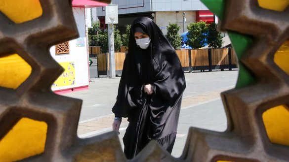 An Iranian woman, wearing a protective face mask, walks down a street in the capital Tehran on July 22, 2020. [Atta Kenare/AFP]