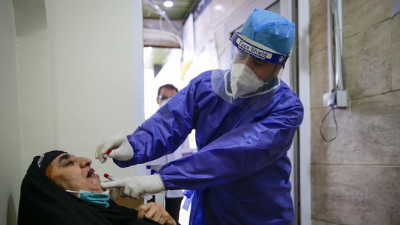 A doctor in Tehran administers a COVID-19 test to a woman. [Fatemeh Aali/Mehr]