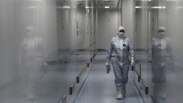 An employee wearing protective equipment walks in a passage at a Russian biotech company that is developing a coronavirus vaccine in Strelna on May 20. [Olga Maltseva/AFP]