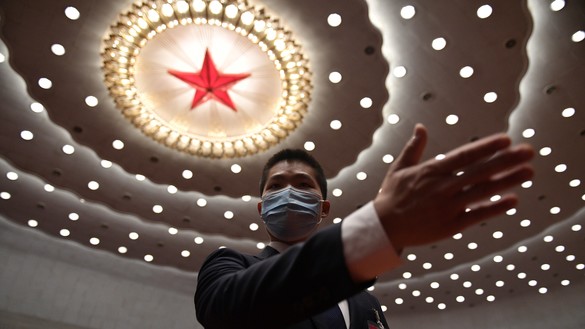 A security guard gestures after the closing session of the National People's Congress at the Great Hall of the People in Beijing on May 28, 2020. [Nicolas Asfouri/AFP]