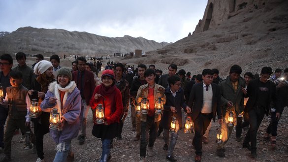 Holding lamps to light their path, local residents and activists walk to the foot of the site where the Salsal Buddha once stood, during a March 9 ceremony marking the 20th anniversary of its destruction. [Wakil Kohsar/AFP]