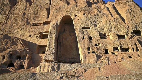 Visitors descending on March 4 from the alcove where one of the Buddhas of Bamiyan once stood give a sense of the massive scale of the statues, blasted out of the cliff by the Taliban. [Wakil Kohsar/AFP]