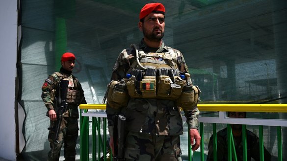 Afghan National Army soldiers stand guard at a damaged petrol station in Kabul, near the scene of an attack on a convoy of Afghan security forces, on April 21. [Wakil Kohsar/AFP]